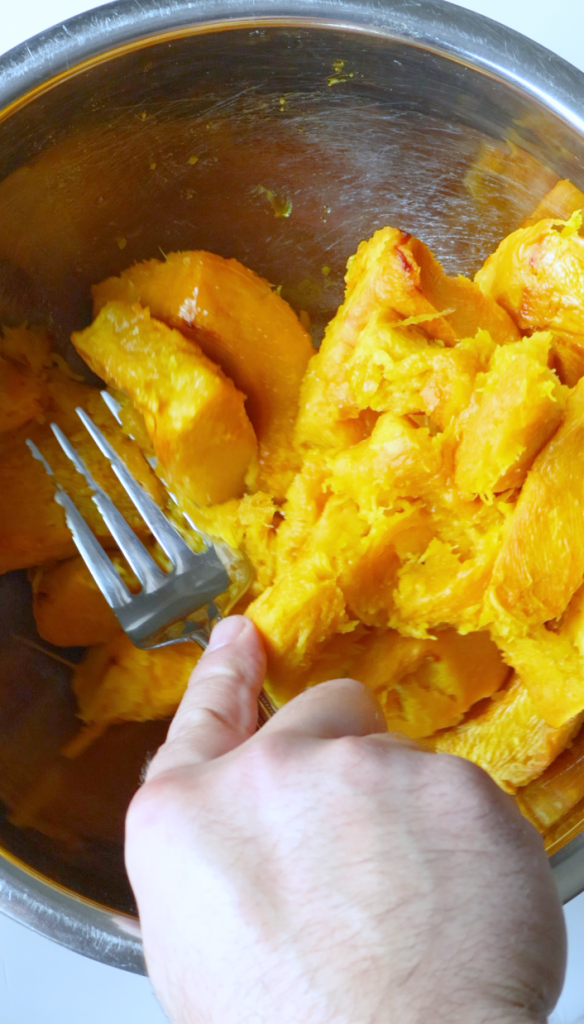 Remove the skin from your baked pumpkin, then mash pumpkin with chopped cilantro, black pepper, red chili flakes, coriander, garlic powder and salt.